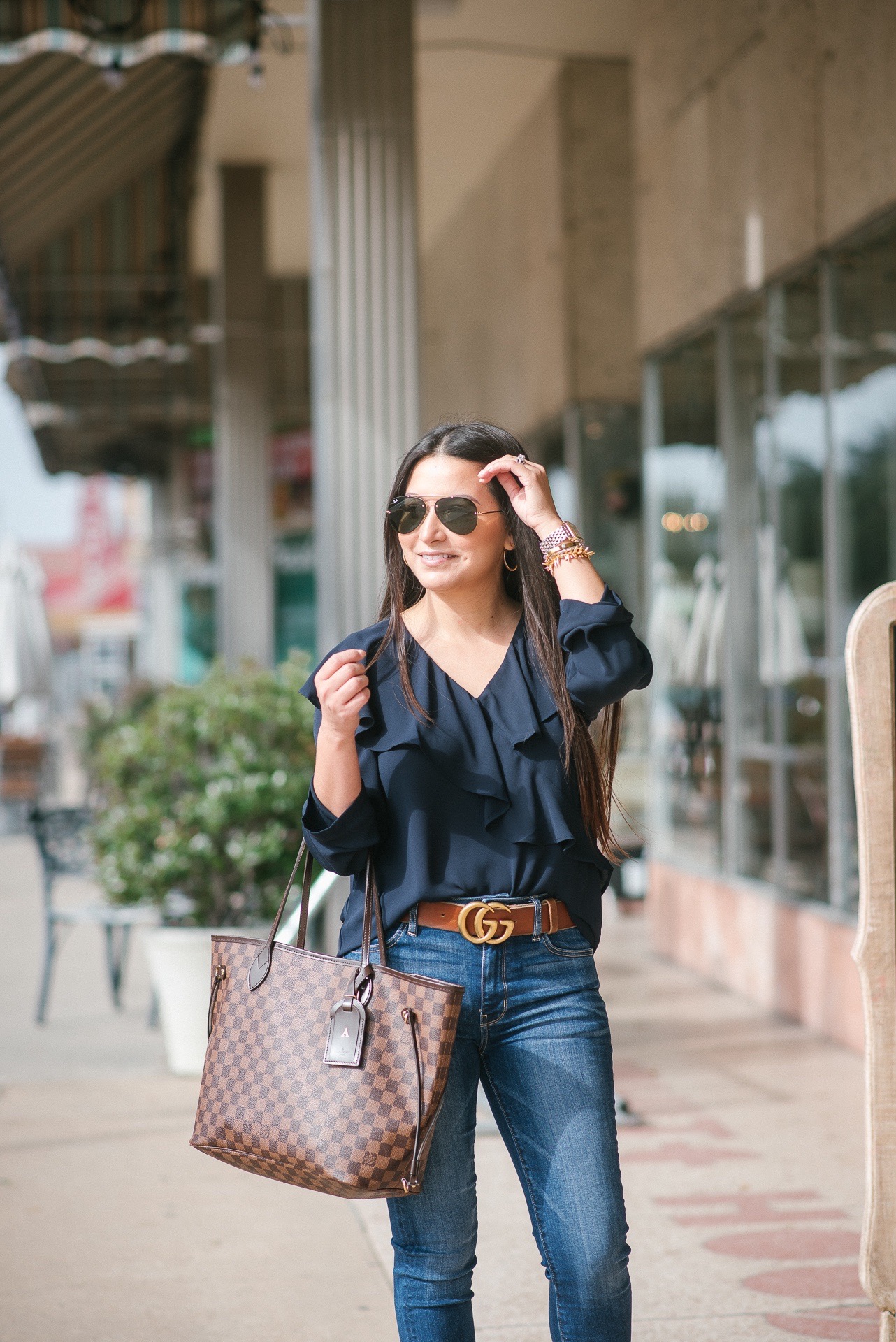 Houston top fashion and lifestyle blogger LuxMommy styles button up top, ripped  jeans, Louis Vuitton bumbag, and vans sneakers